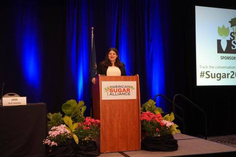 Rep. Stevens speaks from a podium at the American Sugar Symposium's 40th Annual Sweetener Symposium 