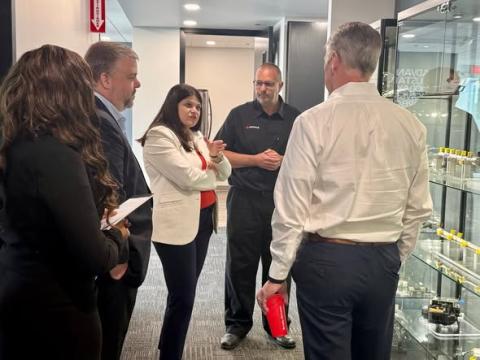 Rep. Stevens (in white blazer) speaks with experts at PHINIA