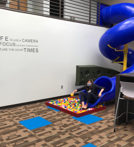 Congresswoman Stevens going down a slide into a ball pit at UBTUS