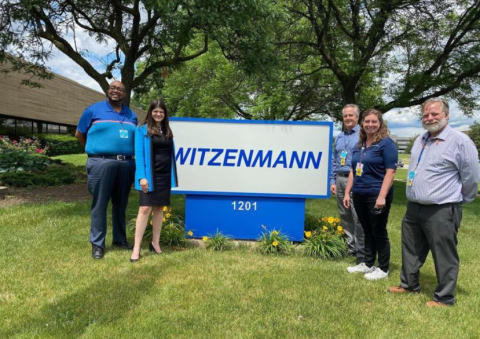 Congresswoman Stevens in front of Witzenmann sign with employees