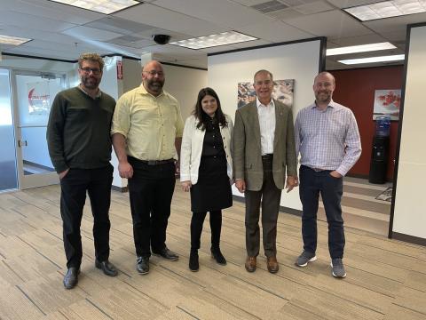 Congresswoman Haley Stevens stands between experts from Pilot Systems International in Farmington Hills, MI